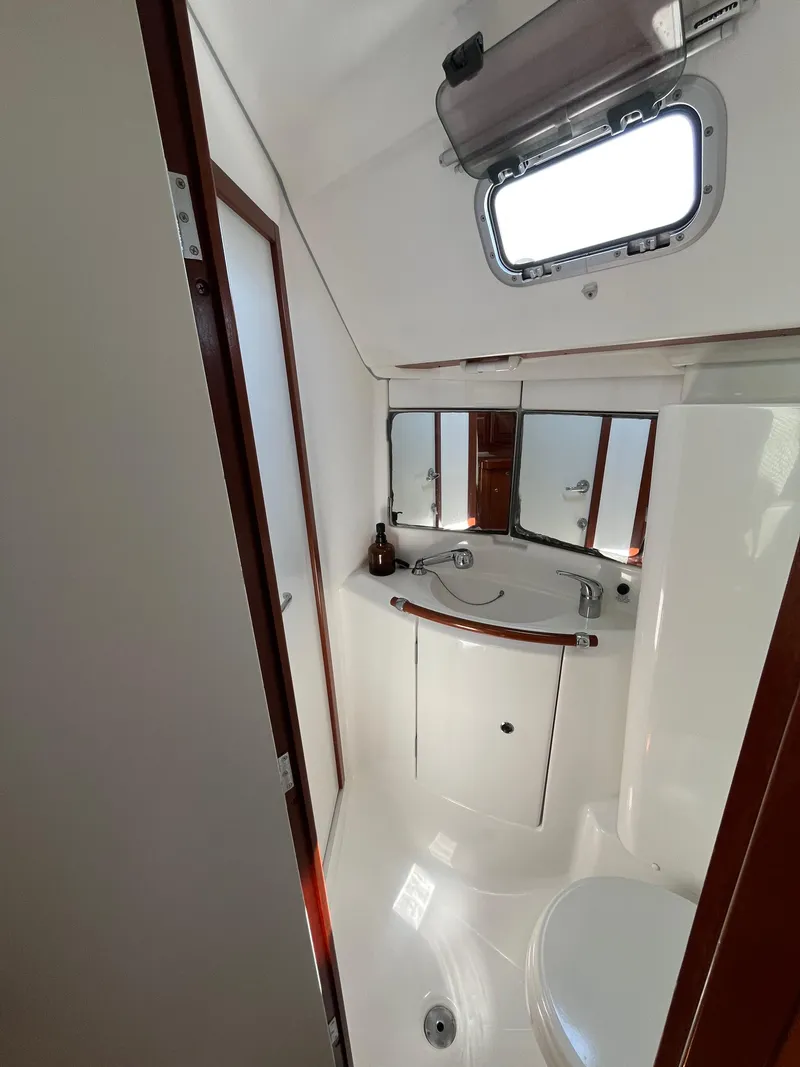 Slide: The Image of 2007 Beneteau 423 yacht bathroom with sink, mirror, and porthole window. - 29