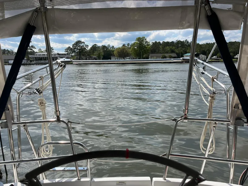 Slide: The Image of Cockpit view from a 2007 Beneteau 423 sailboat overlooking calm waters and distant shoreline. - 32