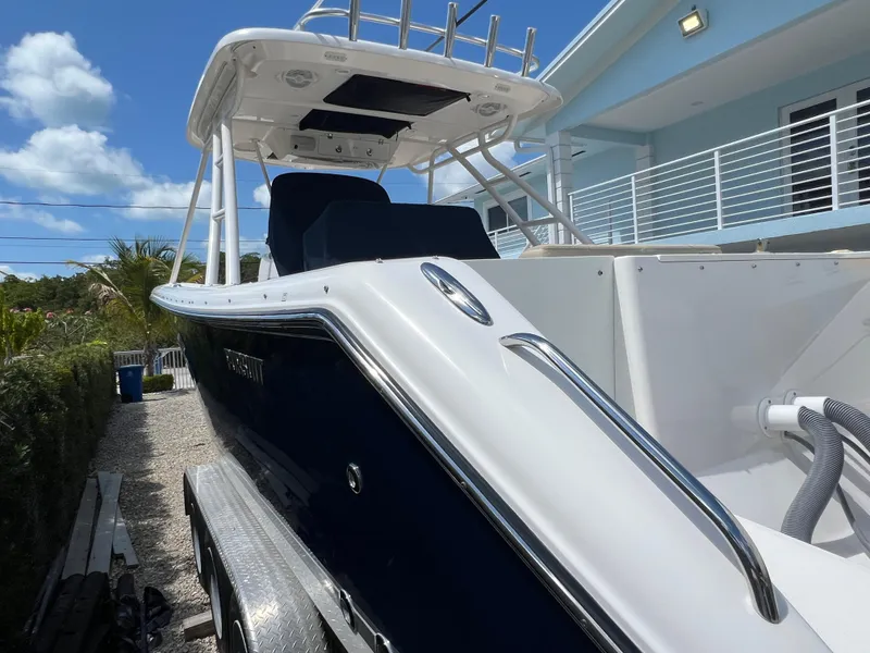 Slide: The Image of 2016 Pursuit S 280 Sport boat on trailer, parked near a modern house under a blue sky. - 10