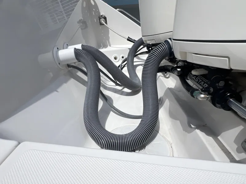 Slide: The Image of 2016 Pursuit S 280 Sport boat engine compartment with hoses and mechanical components. - 11