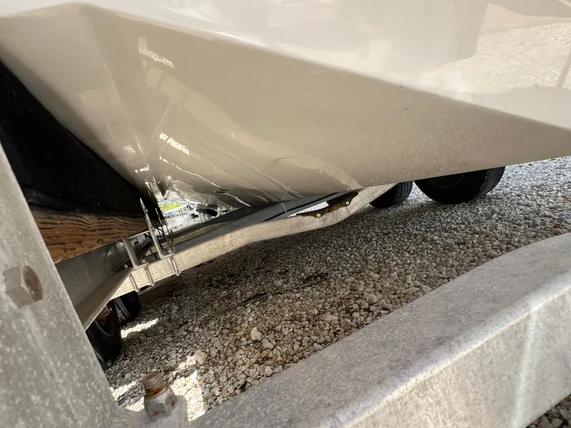 Slide: The Image of 2016 Pursuit S 280 Sport boat hull on a trailer, gravel ground. - 15