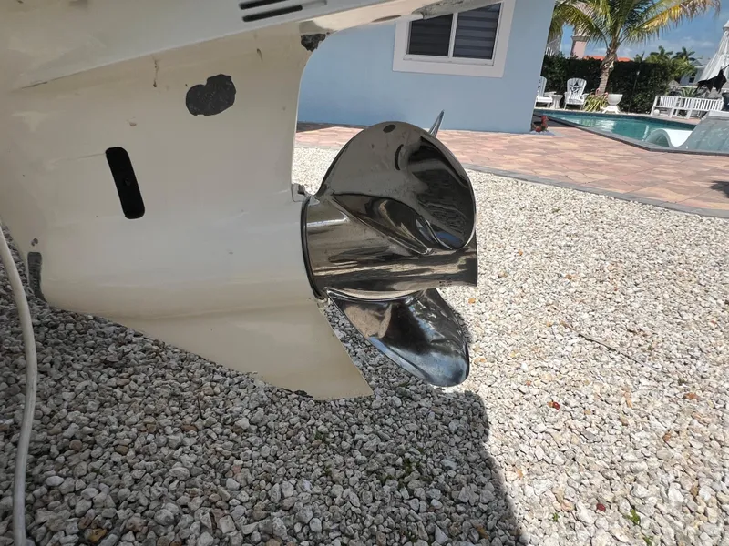 Slide: The Image of 2016 Pursuit S 280 Sport boat propeller on gravel near poolside. - 17