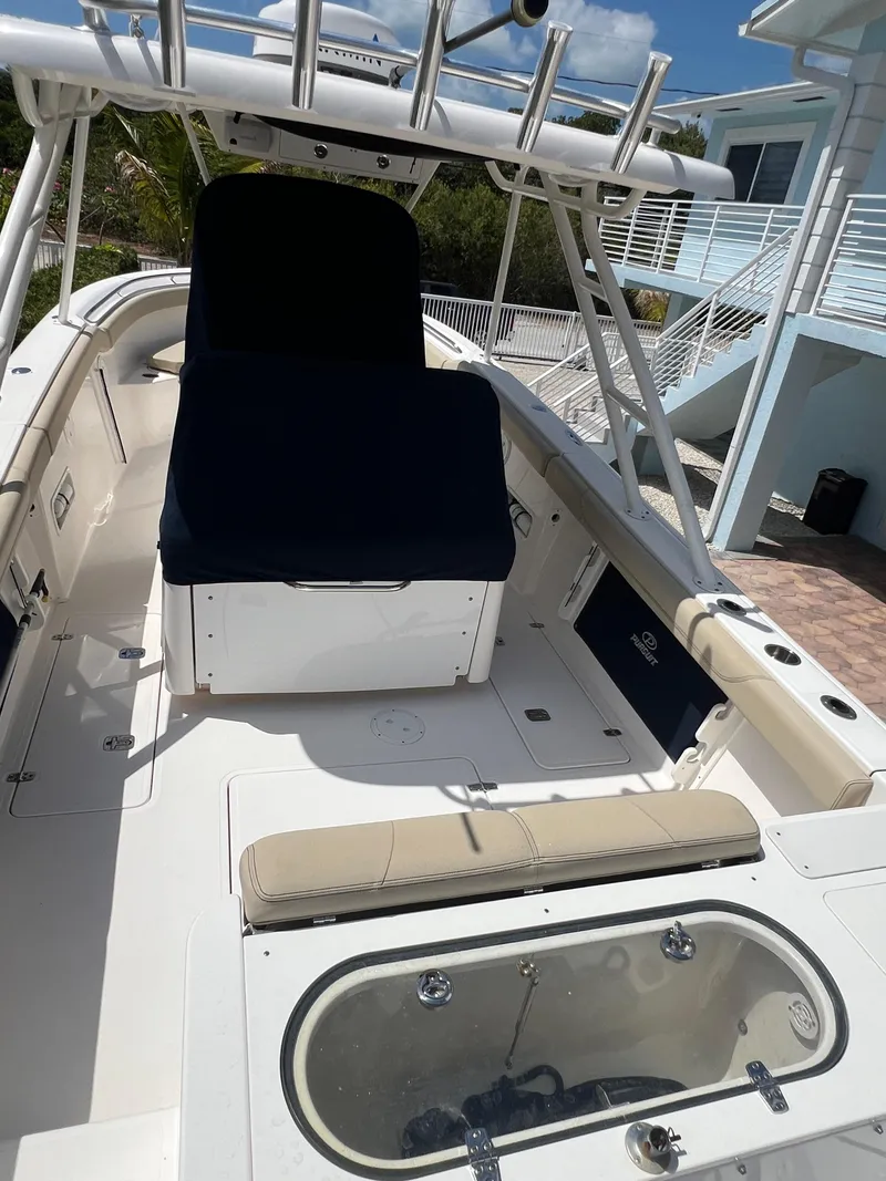 Slide: The Image of 2016 Pursuit S 280 Sport boat with seating and storage, docked near a modern house. - 21