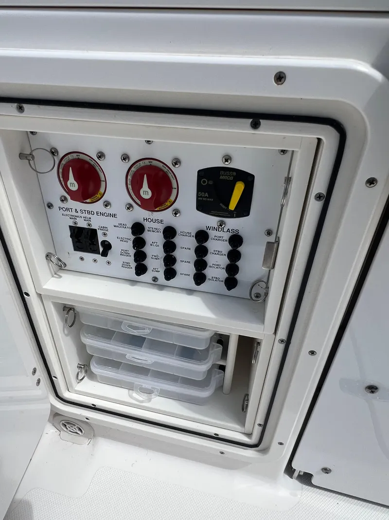 Slide: The Image of Control panel of a 2016 Pursuit S 280 Sport boat with switches and storage compartments. - 28