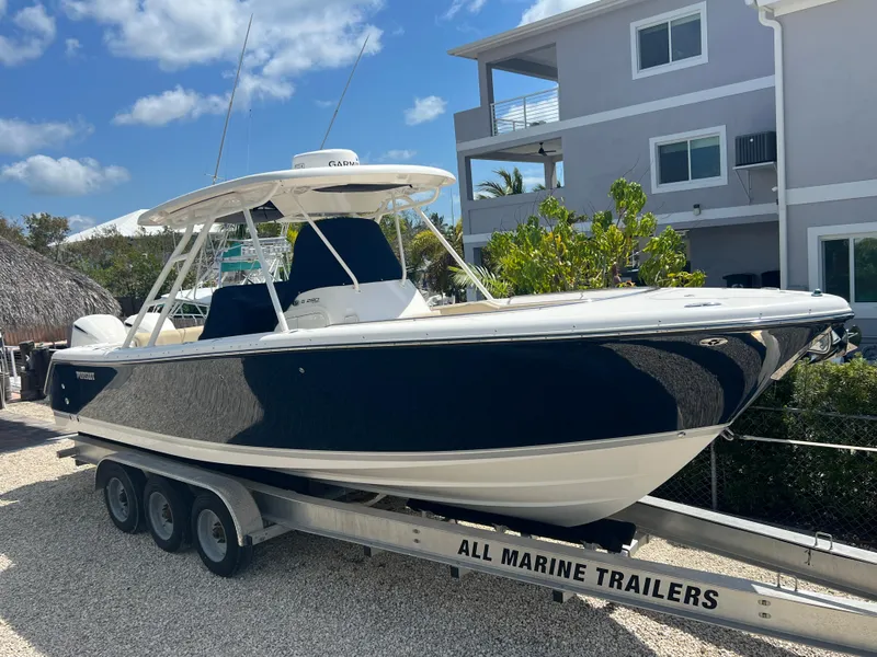 Slide: The Image of 2016 Pursuit S 280 Sport boat on trailer, parked near modern house. - 3