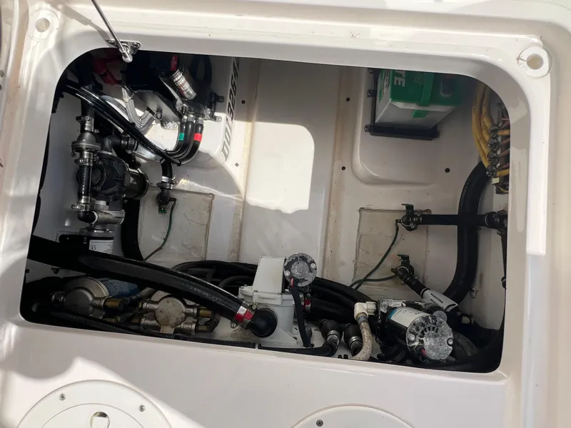 Slide: The Image of Engine compartment of a 2016 Pursuit S 280 Sport boat, showcasing mechanical components and wiring. - 33