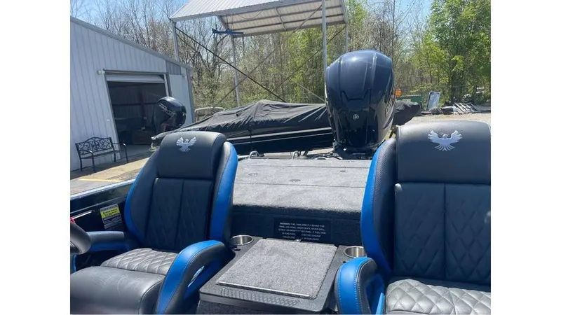 Slide: The Image of 2025 Phoenix 721 ZXL boat interior with dual seats and motor, parked outdoors. - 13