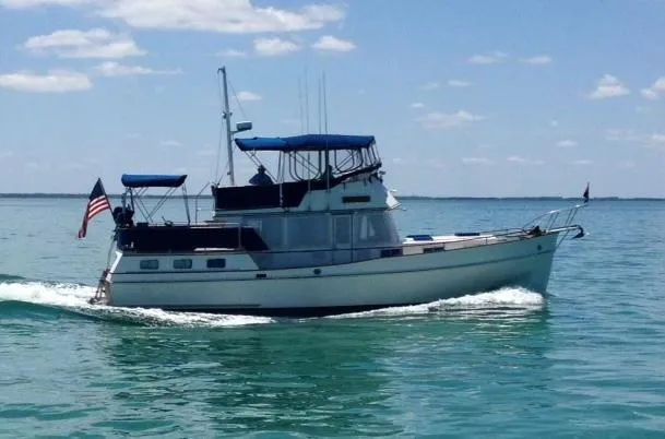 Slide: The Image of 1985 Grand Banks 42 Motoryacht cruising on calm blue waters under a clear sky. - 0