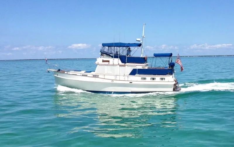 Slide: The Image of 1985 Grand Banks 42 Motoryacht cruising on clear blue waters. - 1