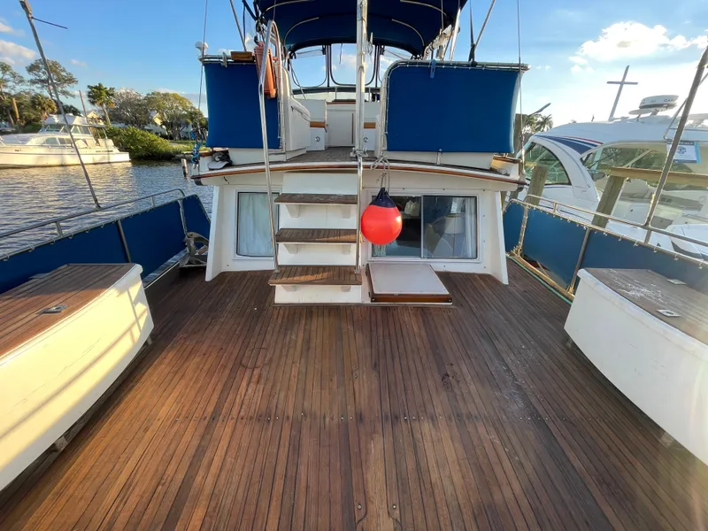 Slide: The Image of 1985 Grand Banks 42 Motoryacht deck with wooden flooring and blue accents. - 13