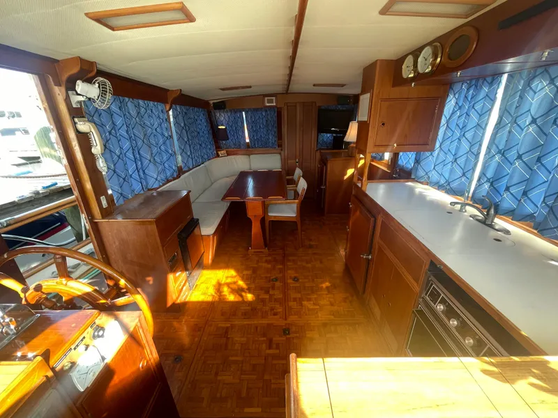 Slide: The Image of Interior of 1985 Grand Banks 42 Motoryacht with wood finish and blue curtains. - 17