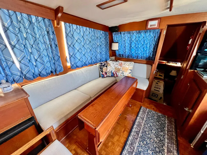 Slide: The Image of Interior of 1985 Grand Banks 42 Motoryacht with blue curtains and wooden furnishings. - 19