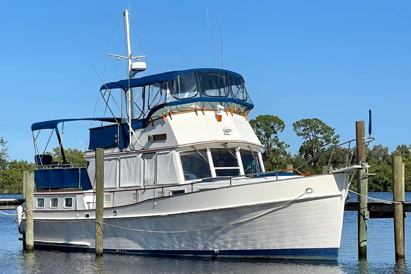 Slide: The Image of 1985 Grand Banks 42 Motoryacht docked on a sunny day, featuring classic design. - 2