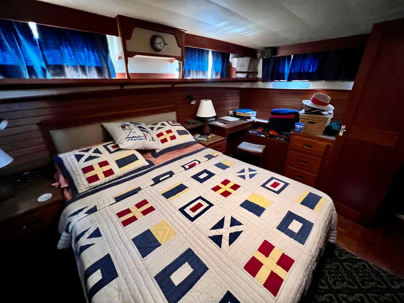 Slide: The Image of Cozy bedroom in 1985 Grand Banks 42 Motoryacht with nautical-themed quilt and wooden interior. - 29