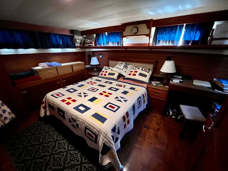 Slide: The Image of Cozy bedroom in 1985 Grand Banks 42 Motoryacht with nautical-themed quilt and wooden interior. - 31