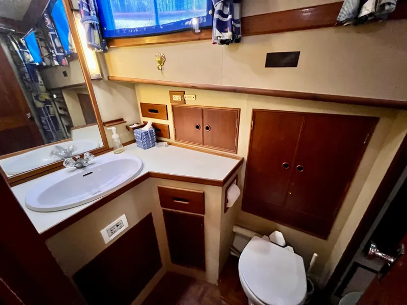 Slide: The Image of 1985 Grand Banks 42 Motoryacht bathroom with sink, mirror, and wooden cabinetry. - 34