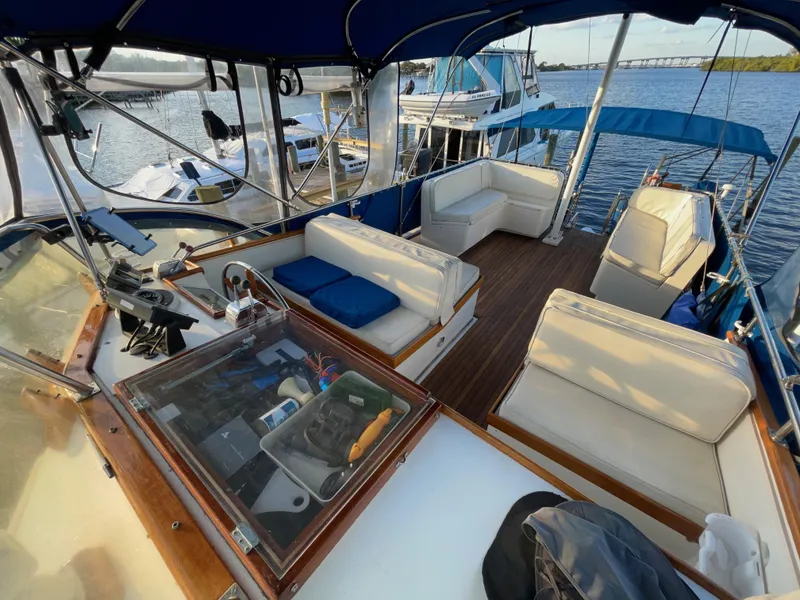 Slide: The Image of 1985 Grand Banks 42 Motoryacht with spacious deck seating and scenic waterfront view. - 6