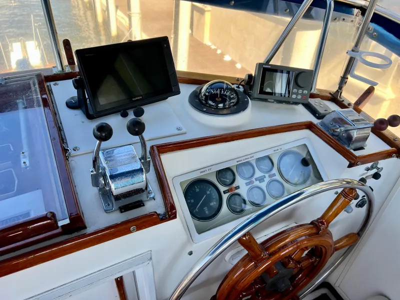 Slide: The Image of 1985 Grand Banks 42 Motoryacht helm with wooden wheel, navigation instruments, and control panel. - 8