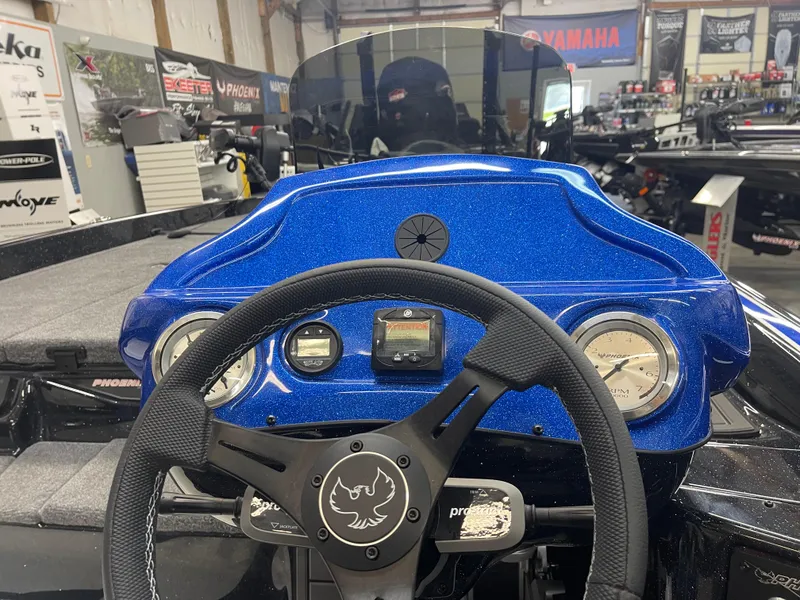 Slide: The Image of Steering wheel and dashboard of a 2025 Phoenix 21 XE boat in a showroom. - 10