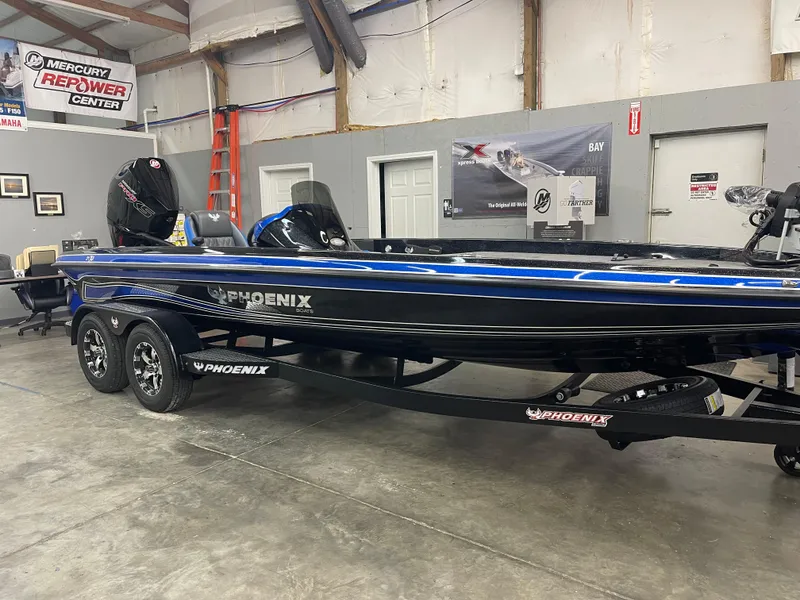 Slide: The Image of 2025 Phoenix 21 XE boat in showroom, blue and black design, Mercury engine visible. - 3