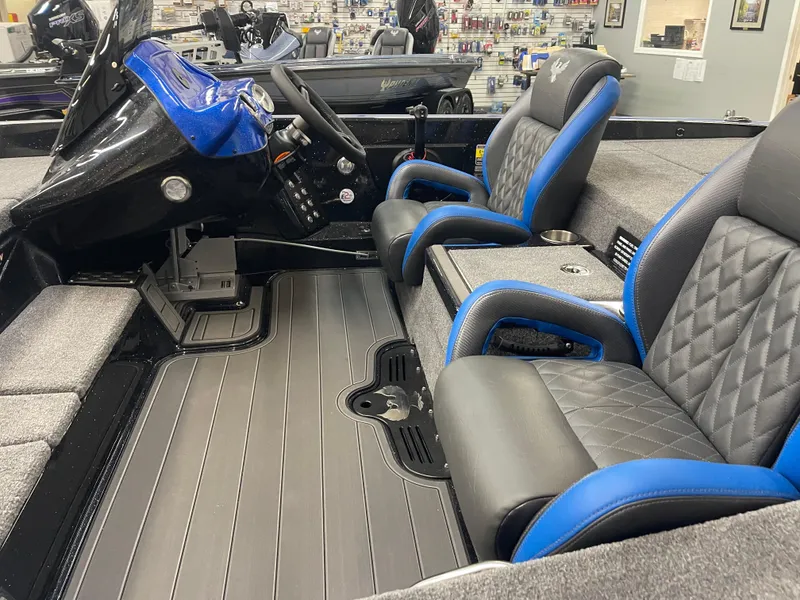 Slide: The Image of 2025 Phoenix 21 XE boat interior with black and blue seats, modern dashboard, and spacious layout. - 8