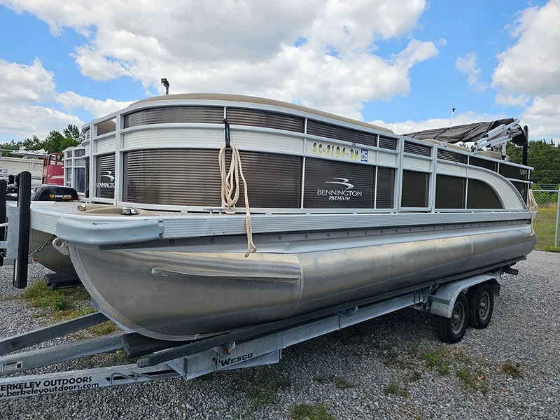 Slide: The Image of 2020 Bennington 22 SSXP pontoon boat on trailer, parked outdoors under a cloudy sky. - 1