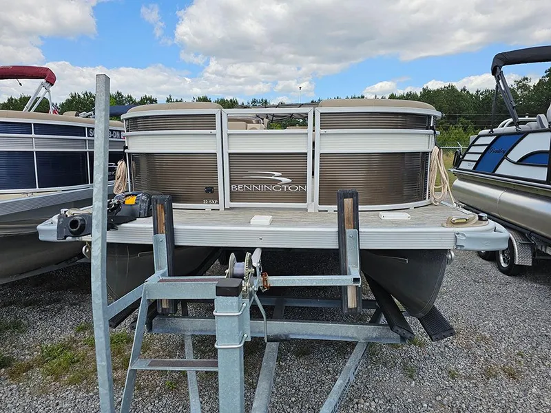 Slide: The Image of 2020 Bennington 22 SSXP pontoon boat on trailer, parked outdoors under cloudy sky. - 2