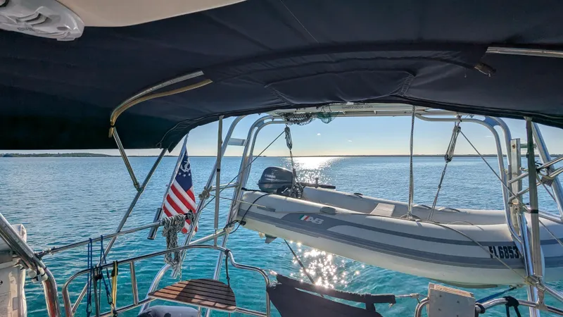 Slide: The Image of Sailboat Hunter 380 (2001) with dinghy on calm water, American flag visible. - 12