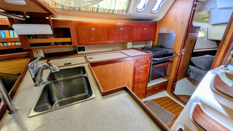 Slide: The Image of Interior of a 2001 Hunter 380 yacht kitchen with wooden cabinets and stainless steel sink. - 16