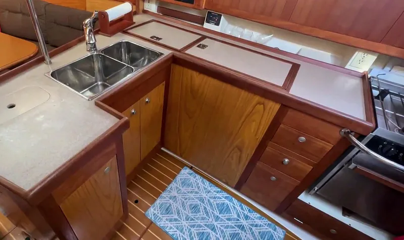 Slide: The Image of Hunter 380 yacht kitchen interior with dual sink, wooden cabinets, and modern appliances, 2001 model. - 17