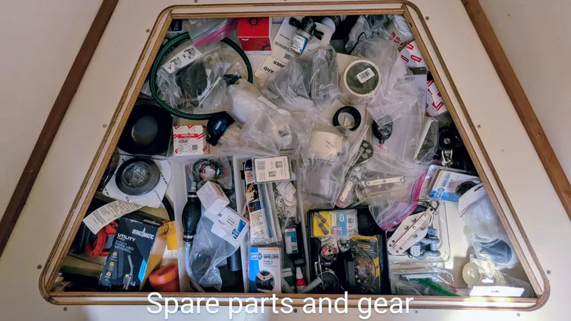 Slide: The Image of Storage compartment filled with various spare parts and gear for a 2001 Hunter 380. - 25