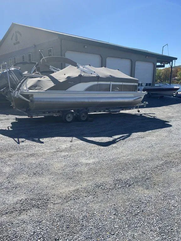 Slide: The Image of 2019 Bennington 23 SSBX pontoon boat parked outside a warehouse on a sunny day. - 4