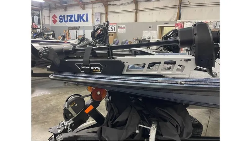 Slide: The Image of 2025 Phoenix 721 ZXL boat with Minn Kota trolling motor in a Suzuki dealership. - 10
