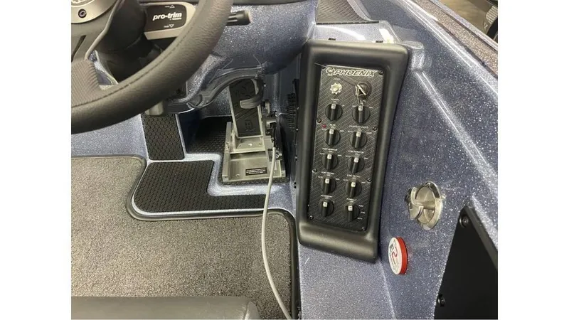 Slide: The Image of Interior control panel of 2025 Phoenix 721 ZXL boat, featuring switches and steering wheel. - 7