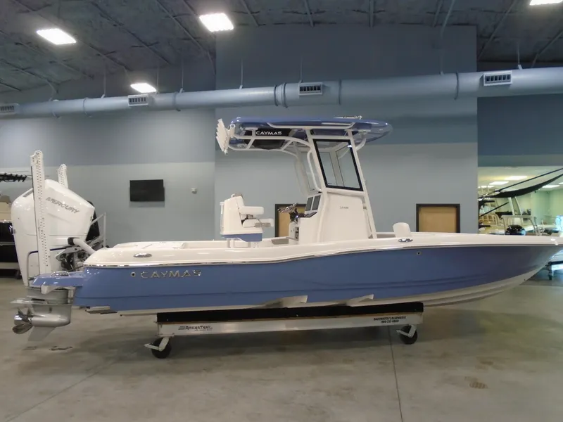 The Image of 2026 Caymas 26 HB boat on trailer, featuring sleek design and powerful outboard motor. - 0