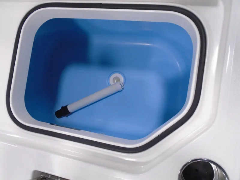 Slide: The Image of 2025 Caymas 26 HB boat livewell with blue interior and white drain pipe. - 10