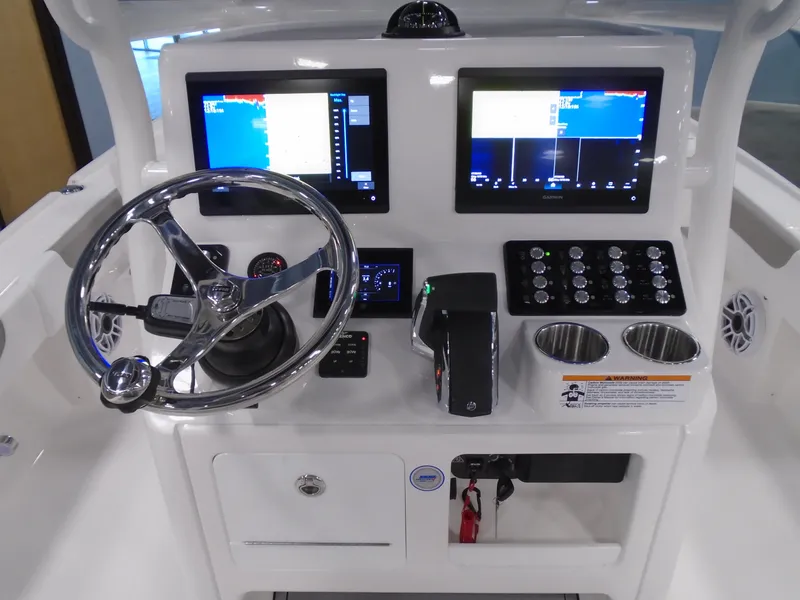 Slide: The Image of Helm of 2025 Caymas 26 HB boat with dual screens and steering wheel. - 11