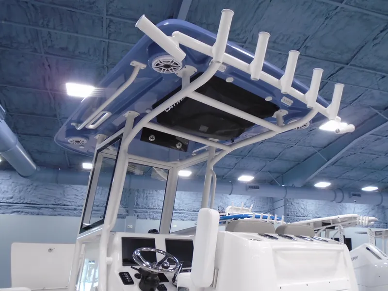 Slide: The Image of 2026 Caymas 26 HB boat interior with white seating and console, docked outdoors. - 15