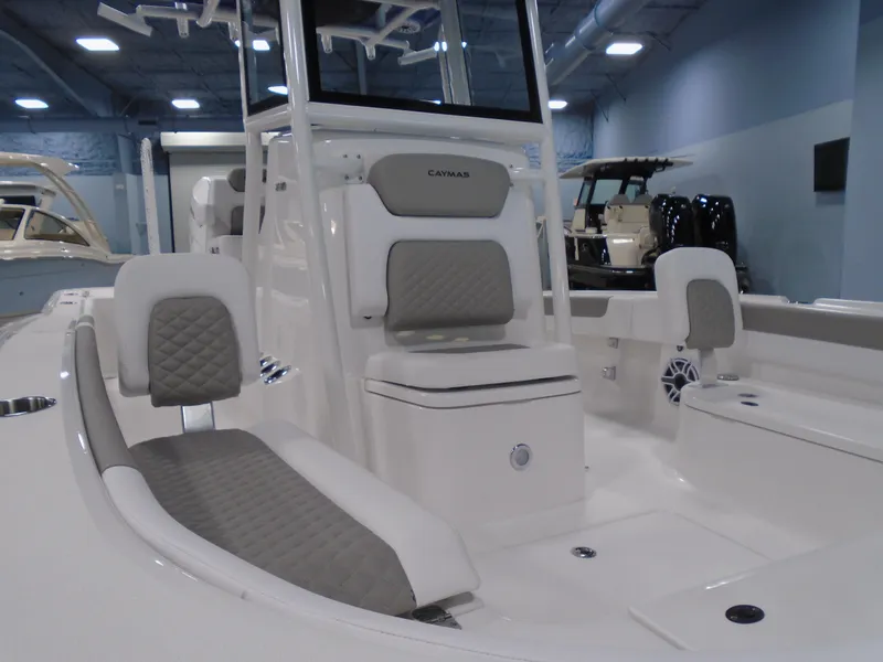 Slide: The Image of 2026 Caymas 26 HB boat with white seating and T-top in a marina setting. - 16