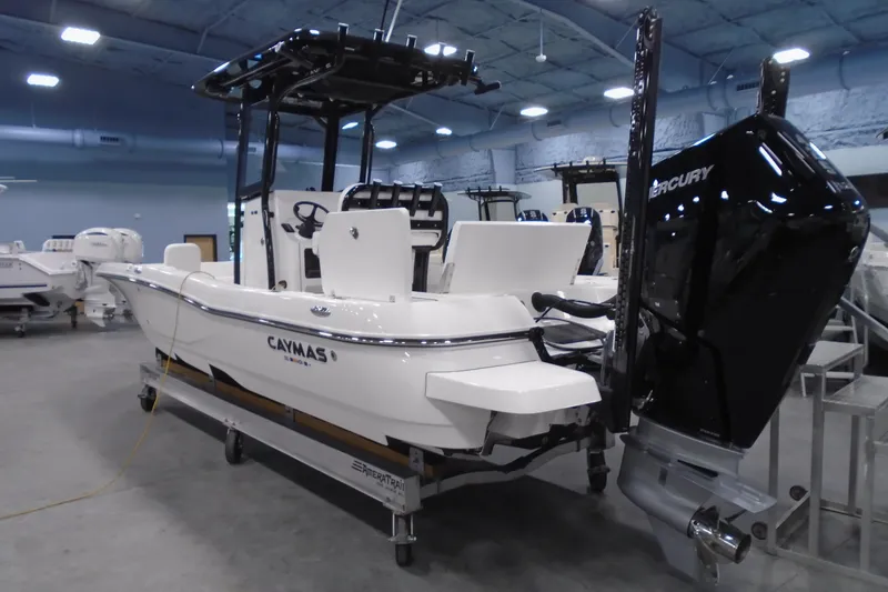 Slide: The Image of 2026 Caymas 26 HB boat with Mercury engine in showroom setting. - 21