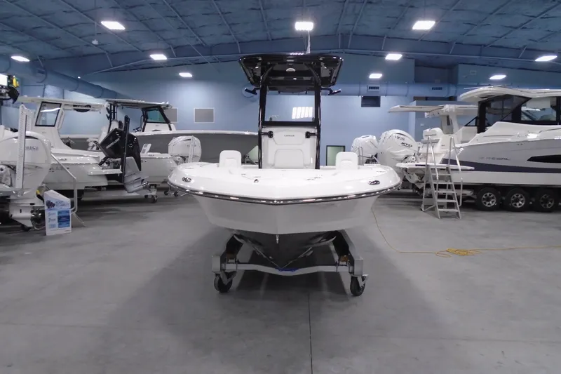 Slide: The Image of 2026 Caymas 26 HB boat displayed in a showroom with other boats. - 24