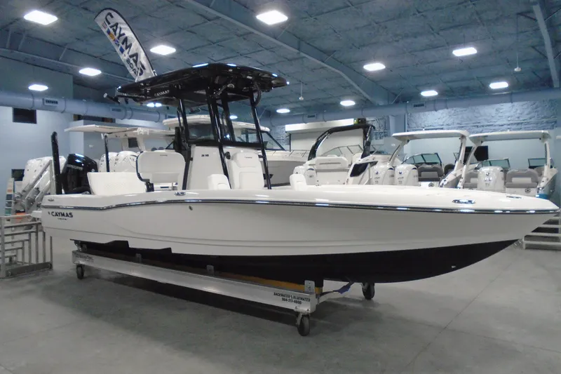 Slide: The Image of 2026 Caymas 26 HB boat displayed in a showroom, featuring sleek design and modern amenities. - 26