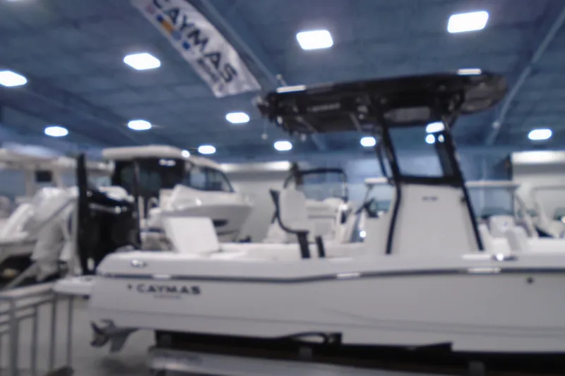 Slide: The Image of 2026 Caymas 26 HB boat displayed indoors at a showroom. - 27