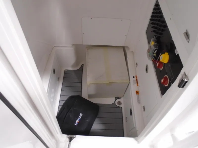 Slide: The Image of 2026 Caymas 26 HB boat on trailer with Mercury engine, parked outside a warehouse. - 5