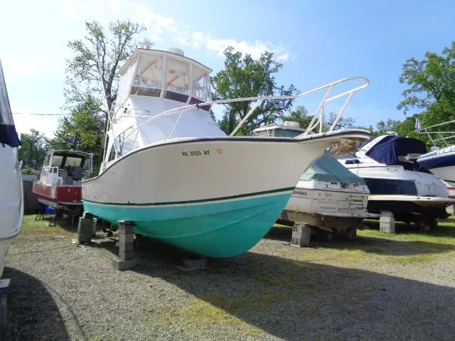 Slide: The Image of 1999 Albemarle 325 Convertible boat on dry dock, white hull with turquoise bottom. - 1