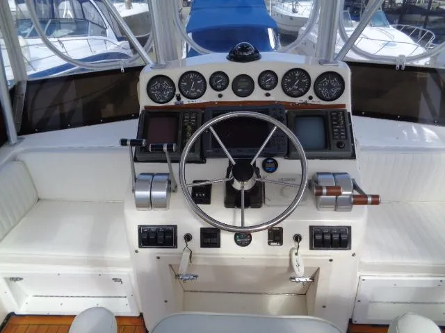 Slide: The Image of 1999 Albemarle 325 Convertible boat helm with gauges, steering wheel, and navigation equipment. - 12