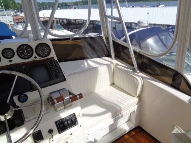 Slide: The Image of 1999 Albemarle 325 Convertible boat cockpit with steering wheel, gauges, and white seating. - 15