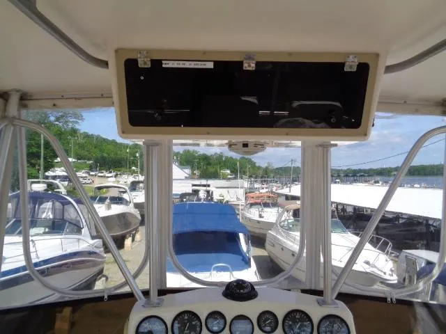 Slide: The Image of 1999 Albemarle 325 Convertible boat dashboard view at marina, surrounded by other boats. - 16