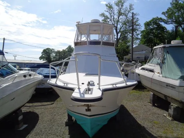 Slide: The Image of 1999 Albemarle 325 Convertible boat on land, surrounded by other vessels. - 2