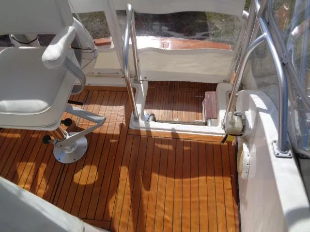 Slide: The Image of 1999 Albemarle 325 Convertible boat interior with wooden flooring and white seating. - 21